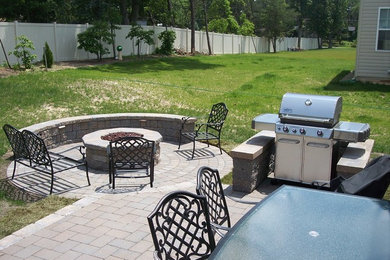 This is an example of a large backyard brick landscaping in Philadelphia with a fire pit.