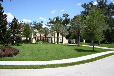 This is an example of a mid-sized full sun front yard concrete paver driveway in Orlando.