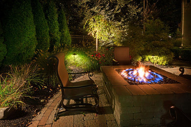 Inspiration for a mid-sized transitional backyard concrete paver landscaping in New York.