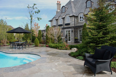 Inspiration for a traditional backyard stone garden path in Toronto.