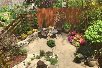 Diseño de jardín clásico grande en patio trasero con fuente, exposición total al sol y adoquines de piedra natural
