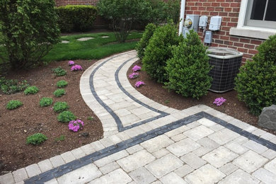 Photo of a mid-sized transitional full sun backyard stone landscaping in Chicago.