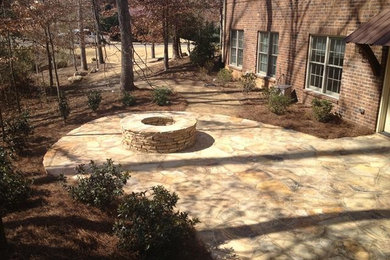 This is an example of a mid-sized shade backyard stone landscaping in Atlanta with a fire pit.
