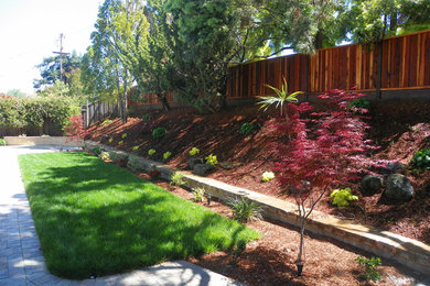 На фото: участок и сад среднего размера на склоне в классическом стиле с подпорной стенкой, полуденной тенью и мощением тротуарной плиткой с