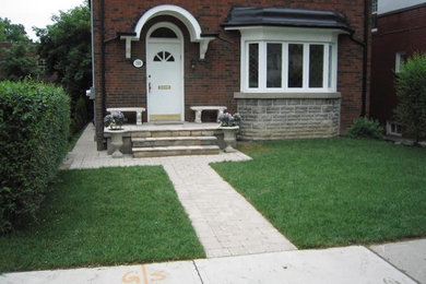 This is an example of a small mediterranean front yard concrete paver landscaping in Toronto.
