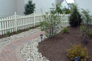 This is an example of a medium sized classic back formal partial sun garden for spring in Columbus with a garden path and brick paving.
