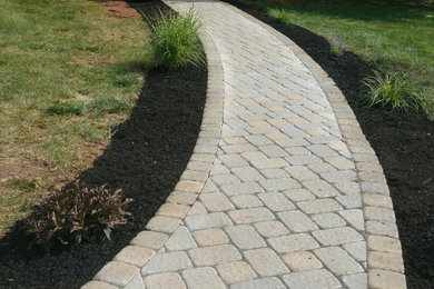 This is an example of a transitional full sun front yard brick walkway in New York.