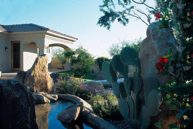 This is an example of a mid-sized modern partial sun backyard concrete paver landscaping in Phoenix.