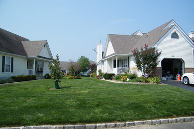 This is an example of a mid-sized traditional full sun front yard landscaping in New York for summer.