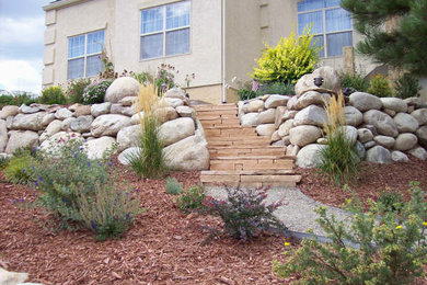 Diseño de jardín de estilo americano de tamaño medio en patio delantero con exposición total al sol y adoquines de piedra natural