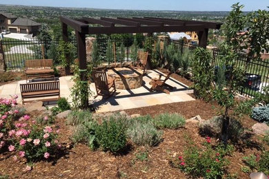Foto de jardín de secano clásico de tamaño medio en patio trasero con brasero, exposición total al sol y adoquines de piedra natural
