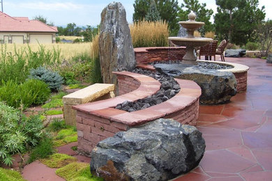 Ejemplo de jardín tradicional de tamaño medio en patio trasero con fuente, exposición total al sol y adoquines de piedra natural
