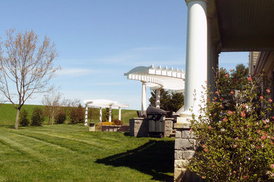 Diseño de jardín grande en patio trasero con exposición parcial al sol