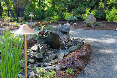 Modelo de jardín de secano clásico renovado extra grande en verano en patio trasero con brasero, exposición parcial al sol y gravilla