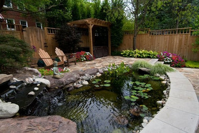 Modelo de jardín grande en patio trasero con fuente y adoquines de piedra natural