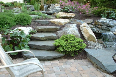 Modelo de jardín clásico grande en patio trasero con exposición total al sol y adoquines de piedra natural