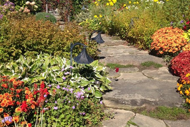 Foto de camino de jardín clásico renovado de tamaño medio en patio trasero con jardín francés, exposición total al sol y adoquines de piedra natural