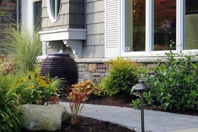 Photo of a medium sized classic front formal full sun garden for spring in Seattle with a garden path and natural stone paving.