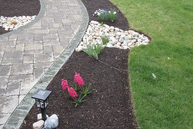 Imagen de jardín grande en patio delantero con exposición parcial al sol y adoquines de piedra natural