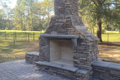 Design ideas for a large backyard stone landscaping in Charleston with a fire pit.