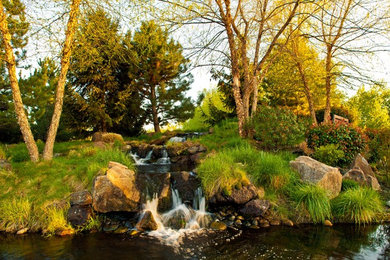 Großer, Halbschattiger Garten hinter dem Haus mit Wasserspiel und Natursteinplatten in Boise