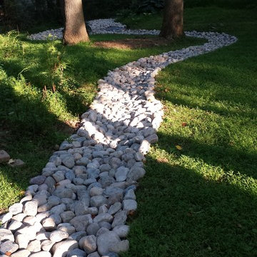 Landscaping and river rock drainage swale