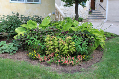 Foto de jardín clásico de tamaño medio en patio delantero con adoquines de hormigón