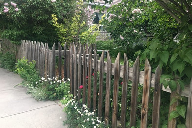 Foto di un piccolo giardino formale vittoriano esposto in pieno sole davanti casa in estate con un ingresso o sentiero