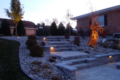 Ejemplo de jardín clásico renovado en patio trasero con exposición total al sol y adoquines de piedra natural