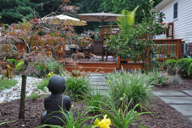Foto de jardín actual grande en verano en patio trasero con exposición parcial al sol y adoquines de hormigón