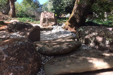 Diseño de jardín clásico en patio trasero con adoquines de piedra natural