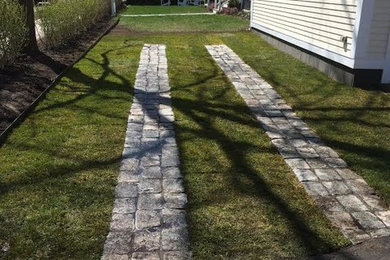 Photo of a mid-sized traditional front yard concrete paver driveway in Boston.