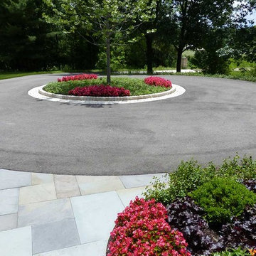 Large circular driveway with a center island intersects with bluestone walkway
