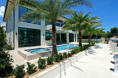 Photo of a medium sized mediterranean back formal full sun garden for summer in Miami with a potted garden and concrete paving.