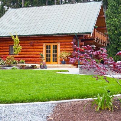 Photo of a mid-sized rustic partial sun backyard concrete paver landscaping in Seattle for summer.