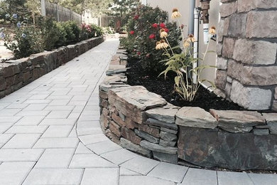 Design ideas for a large coastal partial sun side yard brick retaining wall landscape in New York for summer.