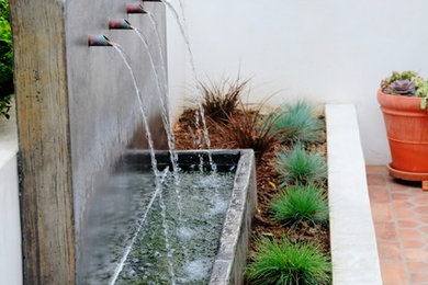 Inspiration for a mid-sized mediterranean partial sun backyard concrete paver landscaping in Los Angeles for summer.