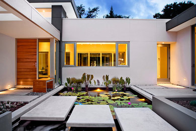 This is an example of a large mid-century modern full sun courtyard concrete paver and wood fence landscaping in Other.