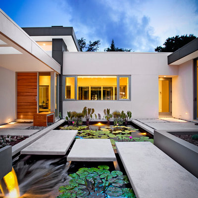 This is an example of a large contemporary full sun front yard concrete paver landscaping in Tampa.