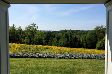 Photo of a large farmhouse hillside stone landscaping in Burlington for summer.