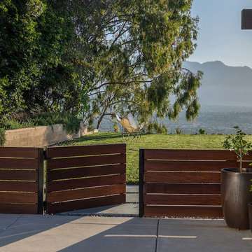 Low ipe fence and gate with lawn and view in background