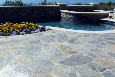 This is an example of an eclectic full sun backyard stone water fountain landscape in Orange County for summer.