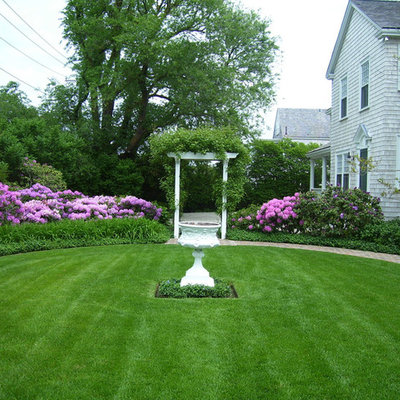 Inspiration for a large traditional full sun front yard brick water fountain landscape in Boston.