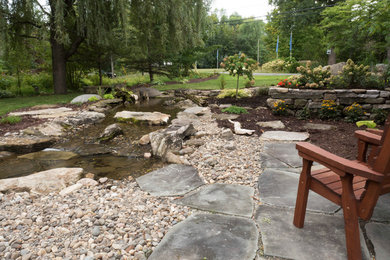 Photo of a huge contemporary full sun backyard stone pond in Other for summer.