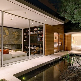 Mittelgroßer Mid-Century Garten neben dem Haus mit Teich, direkter Sonneneinstrahlung und Betonplatten in Los Angeles