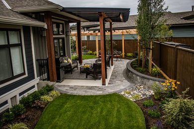 Inspiration for a mid-sized traditional privacy backyard concrete paver landscaping in Vancouver.