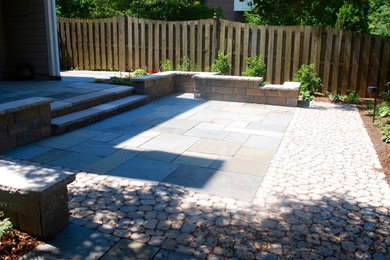 Modelo de jardín clásico renovado de tamaño medio en patio trasero con exposición parcial al sol y adoquines de hormigón