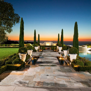 Idee per un ampio giardino mediterraneo esposto in pieno sole dietro casa in estate con fontane e pavimentazioni in pietra naturale