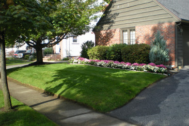 Photo of a mid-sized traditional shade front yard mulch driveway in Boston for spring.