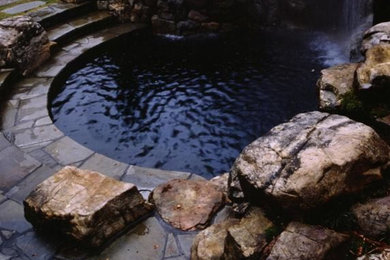 Imagen de jardín ecléctico grande en patio trasero con fuente, exposición parcial al sol y adoquines de piedra natural